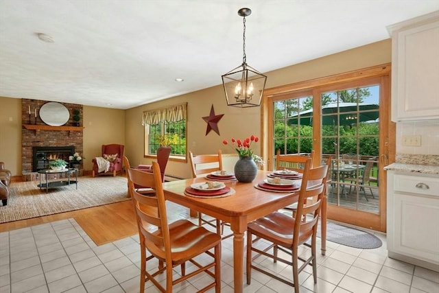 8 Adams Rd, Grafton, MA 01519 - dining area with light tile patterned flooring, a chandelier, and a brick fireplace