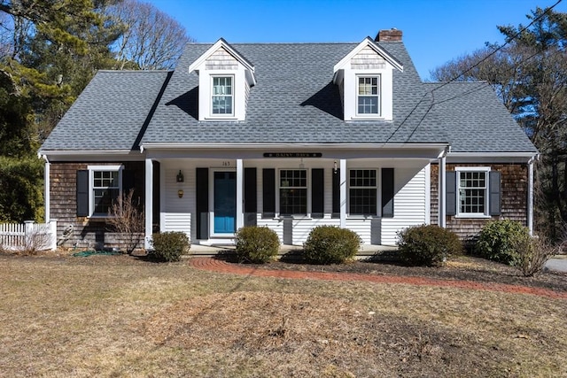 cape cod home with a porch, a front lawn, and roof with shingles