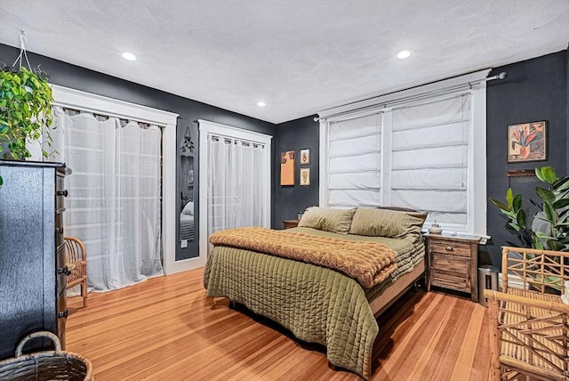 bedroom with light wood-style floors, recessed lighting, and a textured ceiling