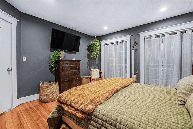 bedroom featuring wood finished floors, recessed lighting, and baseboards