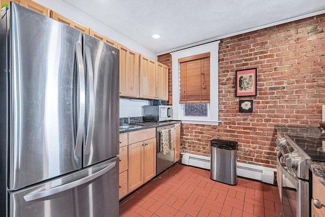 kitchen with appliances with stainless steel finishes, brick wall, brick patterned floors, baseboard heating, and light brown cabinets