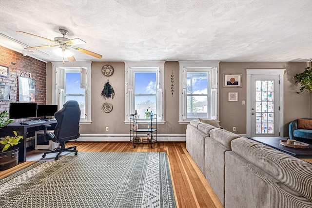 office featuring hardwood / wood-style floors, a textured ceiling, ceiling fan, and baseboards