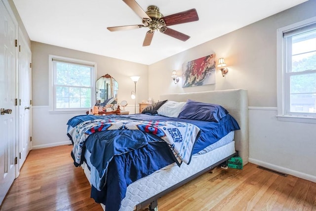 bedroom with multiple windows, visible vents, and wood finished floors