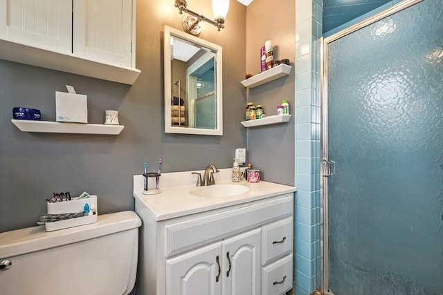 bathroom featuring vanity, toilet, and a shower stall