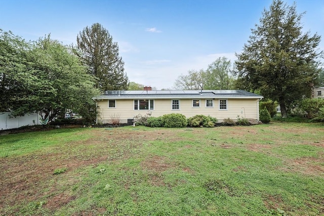 view of front of house featuring a front lawn and solar panels