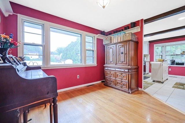sitting room featuring baseboards, light wood-type flooring, plenty of natural light, and visible vents