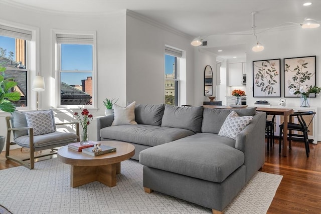 living area with recessed lighting, visible vents, ornamental molding, and wood finished floors