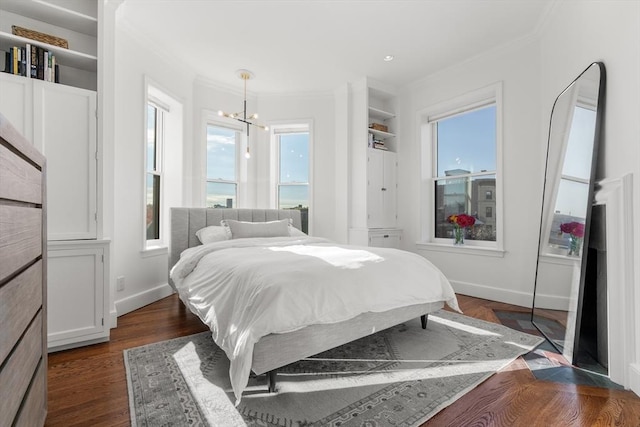 bedroom featuring a chandelier, crown molding, baseboards, and dark wood-style flooring