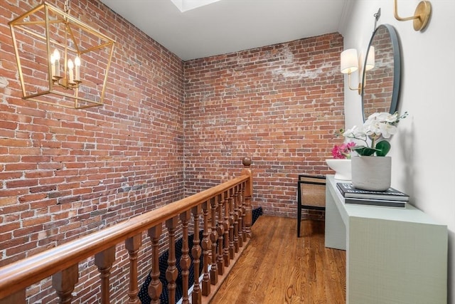 wine cellar featuring wood finished floors and brick wall