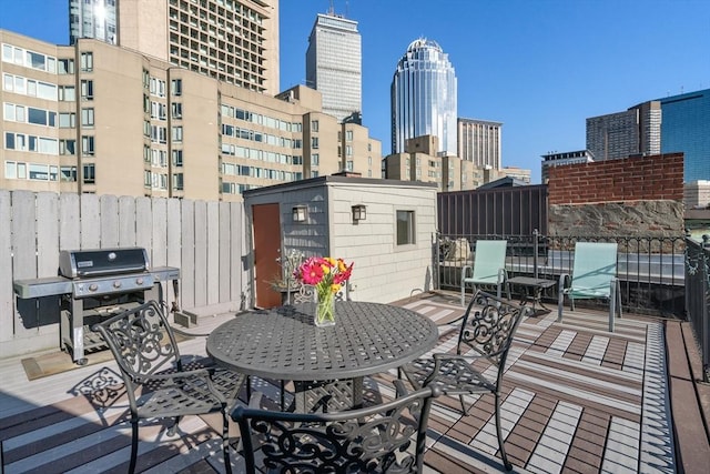 wooden terrace featuring a view of city and a grill