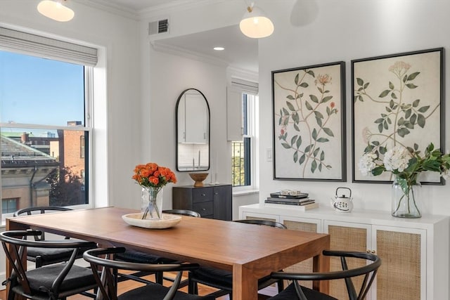 dining room featuring visible vents and ornamental molding