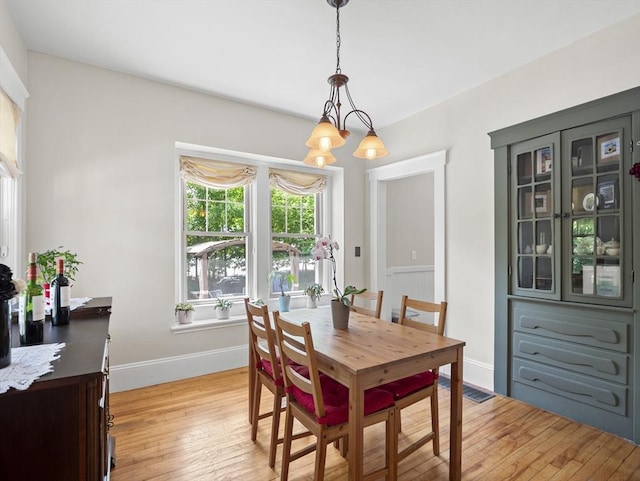 537 Milk St, Fitchburg, MA 01420 - dining space with light wood-type flooring, baseboards, and a chandelier