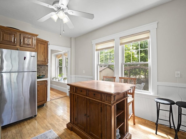 537 Milk St, Fitchburg, MA 01420 - kitchen featuring freestanding refrigerator, light wood-style flooring, plenty of natural light, a ceiling fan, and a wainscoted wall