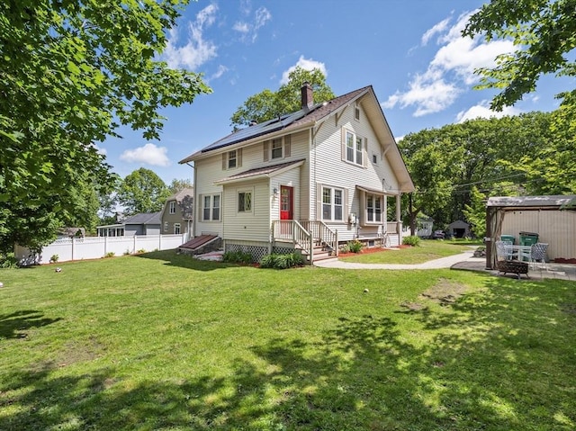 537 Milk St, Fitchburg, MA 01420 - rear view of property with a chimney, solar panels, and an outdoor fire pit