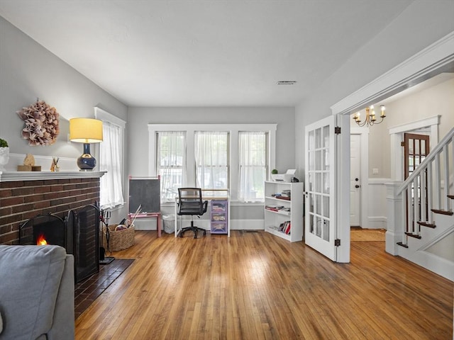 537 Milk St, Fitchburg, MA 01420 - office space with hardwood / wood-style flooring, a chandelier, and a brick fireplace