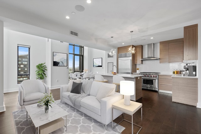 living room with dark hardwood / wood-style flooring, a chandelier, and sink