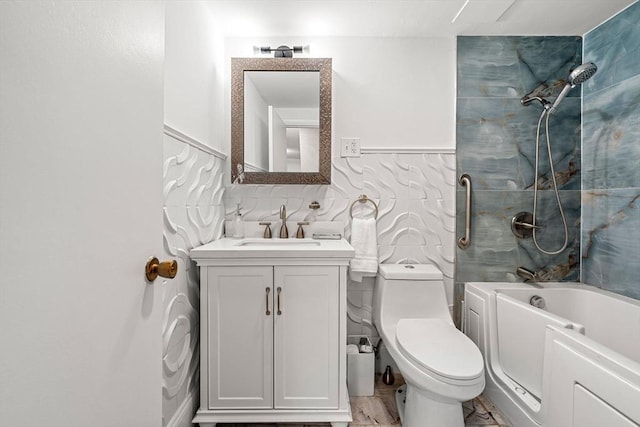 bathroom with vanity, tile walls, toilet, marble finish floor, and shower / bathtub combination