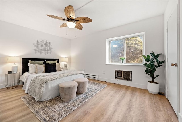 bedroom with baseboards, a baseboard radiator, light wood-style flooring, ceiling fan, and a wall mounted air conditioner