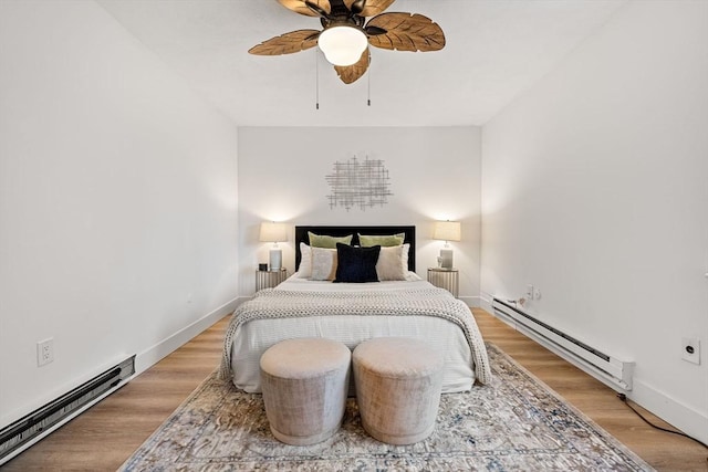 bedroom featuring light wood-style flooring, baseboards, and a baseboard radiator