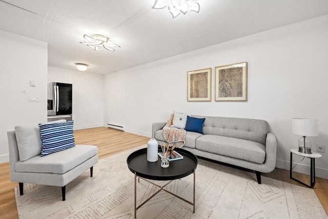 living area featuring a baseboard heating unit, baseboards, and wood finished floors