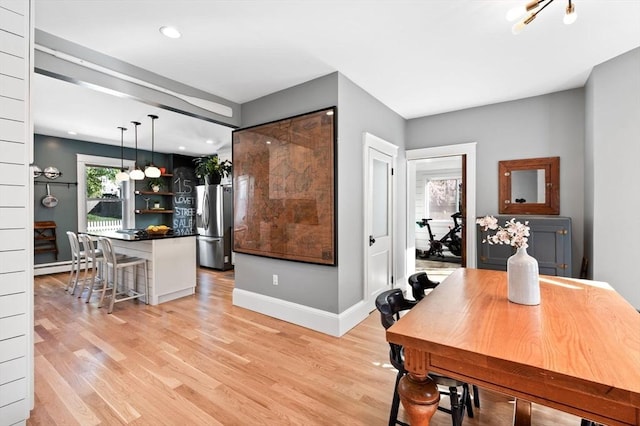 dining space featuring light wood-type flooring, baseboards, a baseboard heating unit, and recessed lighting