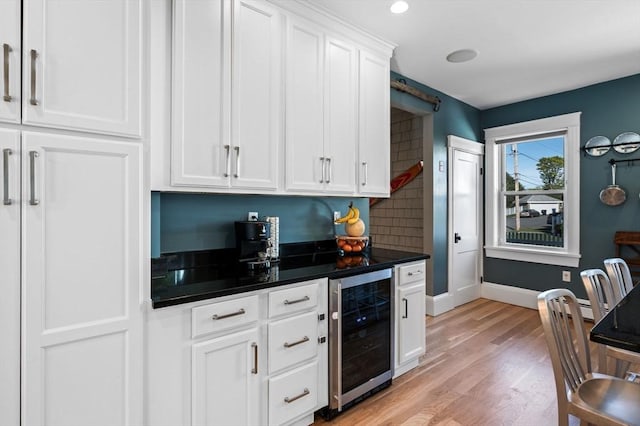 bar with baseboards, backsplash, light wood-style floors, and beverage cooler