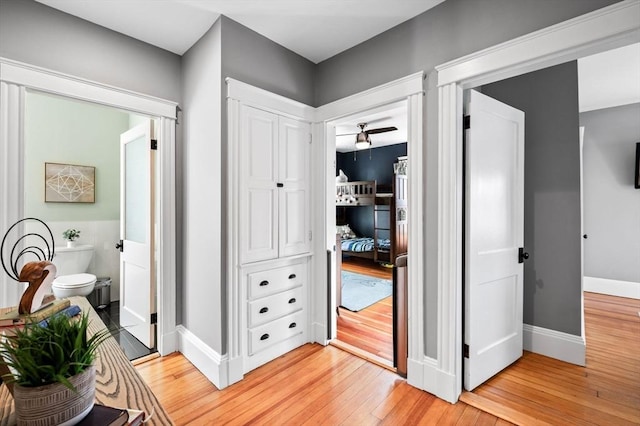 hall with light wood-style floors and baseboards