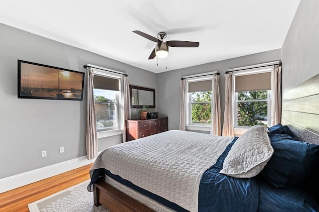 bedroom featuring baseboards, a ceiling fan, and wood finished floors