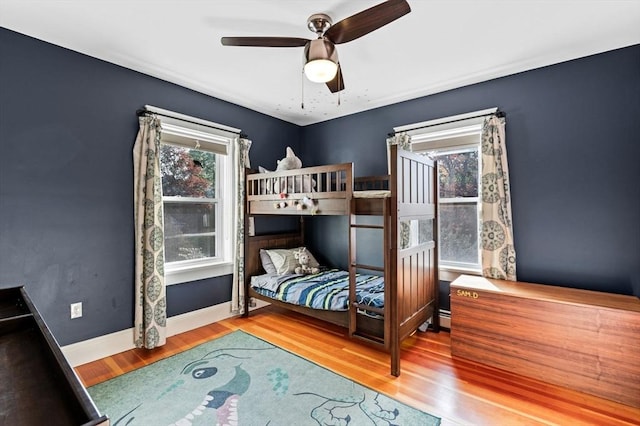bedroom with ceiling fan, baseboards, and wood finished floors