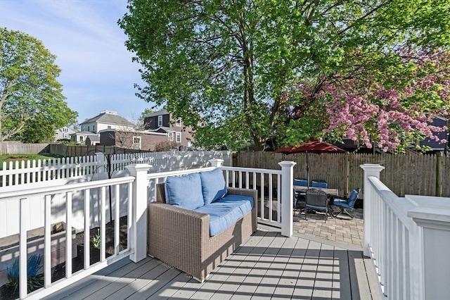 wooden terrace featuring a fenced backyard, outdoor lounge area, outdoor dining space, and a residential view