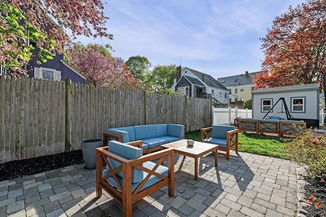 view of patio with a fenced backyard, an outbuilding, and outdoor lounge area
