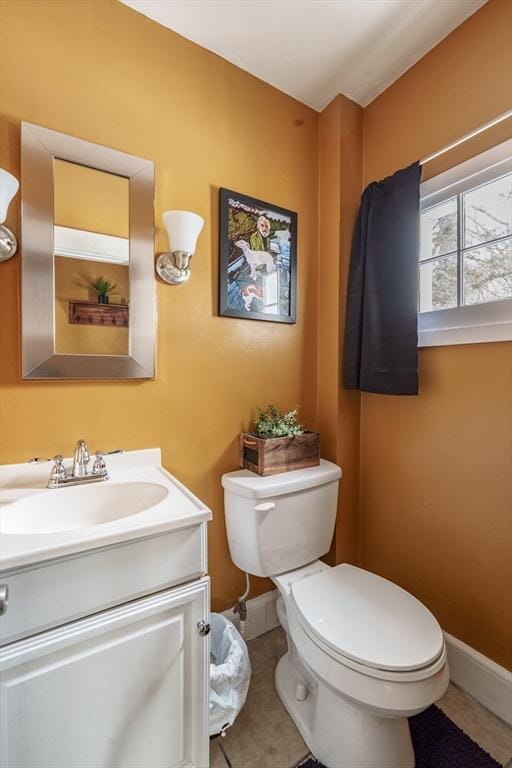 bathroom with toilet, tile patterned flooring, baseboards, and vanity