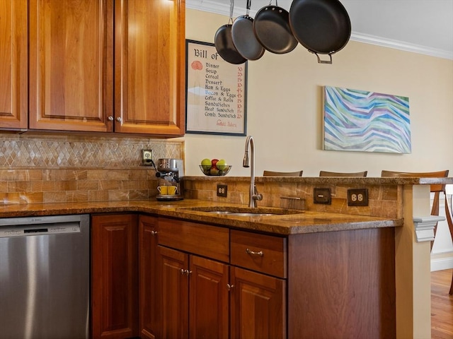 kitchen featuring a sink, tasteful backsplash, stainless steel dishwasher, and ornamental molding