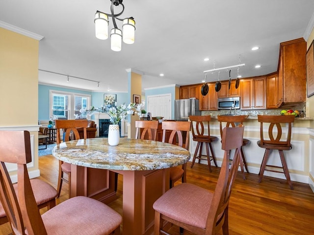 dining area featuring recessed lighting, crown molding, and wood finished floors