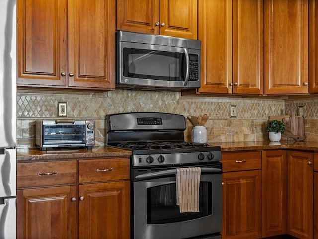 kitchen with brown cabinetry, backsplash, and stainless steel appliances