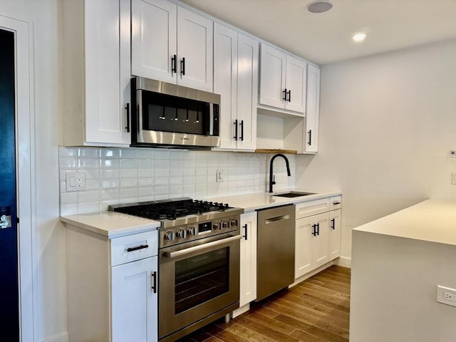 252 Main St Unit 101, Medford, MA 02155 - kitchen featuring appliances with stainless steel finishes, a sink, dark wood-style flooring, light countertops, and recessed lighting