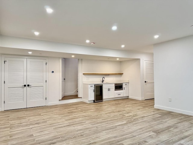 252 Main St Unit 101, Medford, MA 02155 - indoor wet bar featuring wine cooler, baseboards, recessed lighting, light wood finished floors, and stainless steel microwave