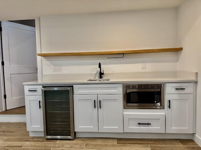 252 Main St Unit 101, Medford, MA 02155 - indoor wet bar featuring wine cooler, stainless steel microwave, and light wood-type flooring