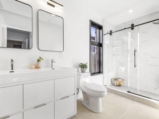 252 Main St Unit 101, Medford, MA 02155 - full bath with toilet, a marble finish shower, double vanity, and tile patterned flooring