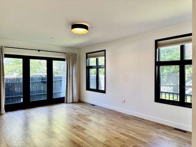 252 Main St Unit 101, Medford, MA 02155 - empty room with healthy amount of natural light, baseboards, and light wood-style floors