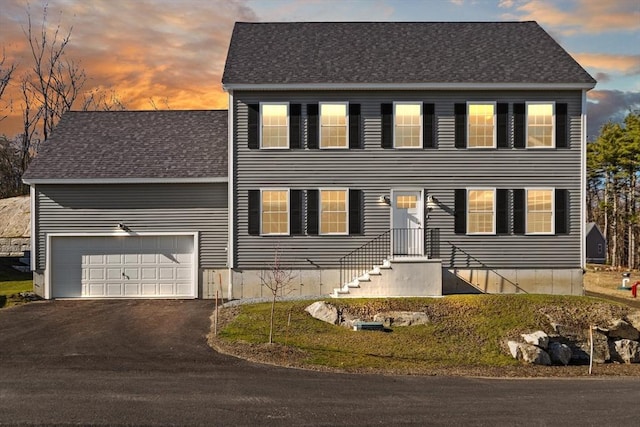 colonial-style house with roof with shingles and driveway