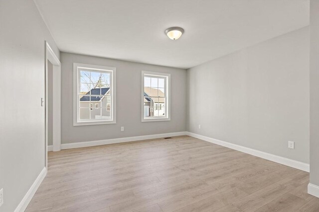 empty room featuring baseboards and light wood-style floors