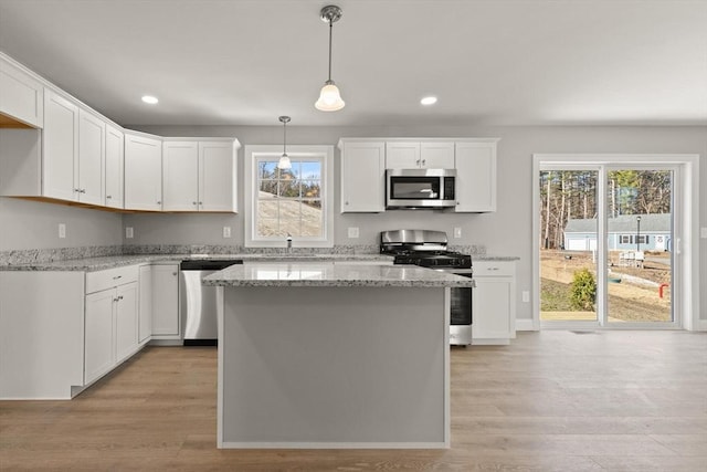 kitchen with recessed lighting, white cabinets, stainless steel appliances, and light wood-type flooring