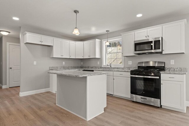 kitchen with appliances with stainless steel finishes, white cabinetry, and light wood-type flooring