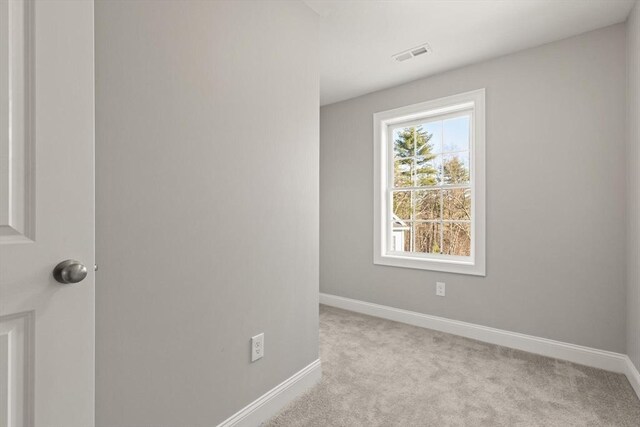 carpeted empty room featuring visible vents and baseboards