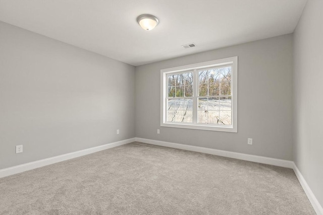 carpeted spare room featuring visible vents and baseboards