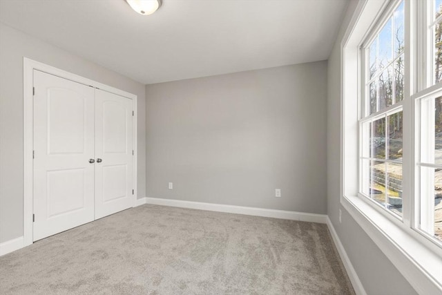 unfurnished bedroom with carpet, baseboards, and a closet