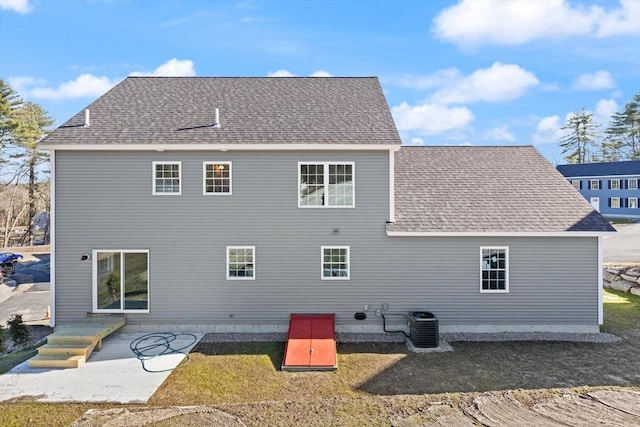 back of house featuring a patio, central AC, and roof with shingles