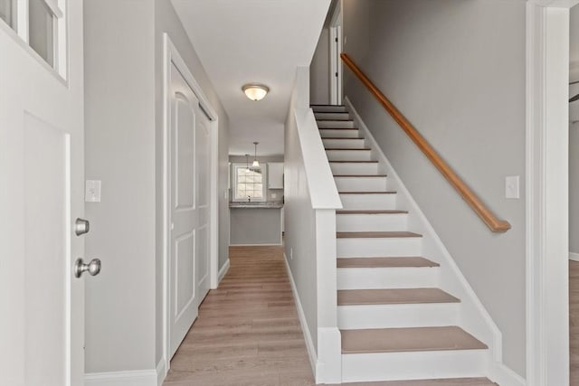staircase featuring baseboards and wood finished floors