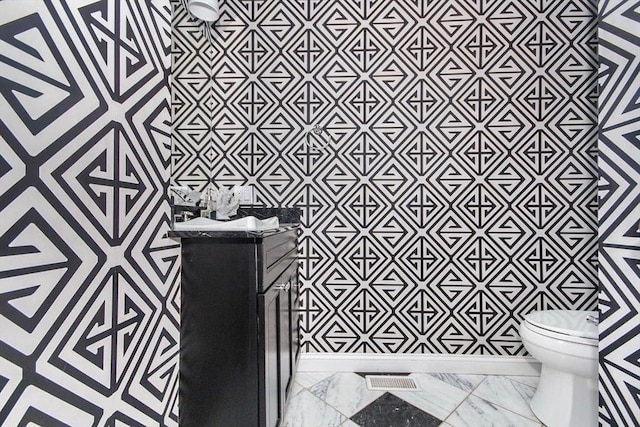 49 Baldwin St Unit 1, Boston, MA 02129 - half bathroom featuring vanity, toilet, and marble look tile flooring